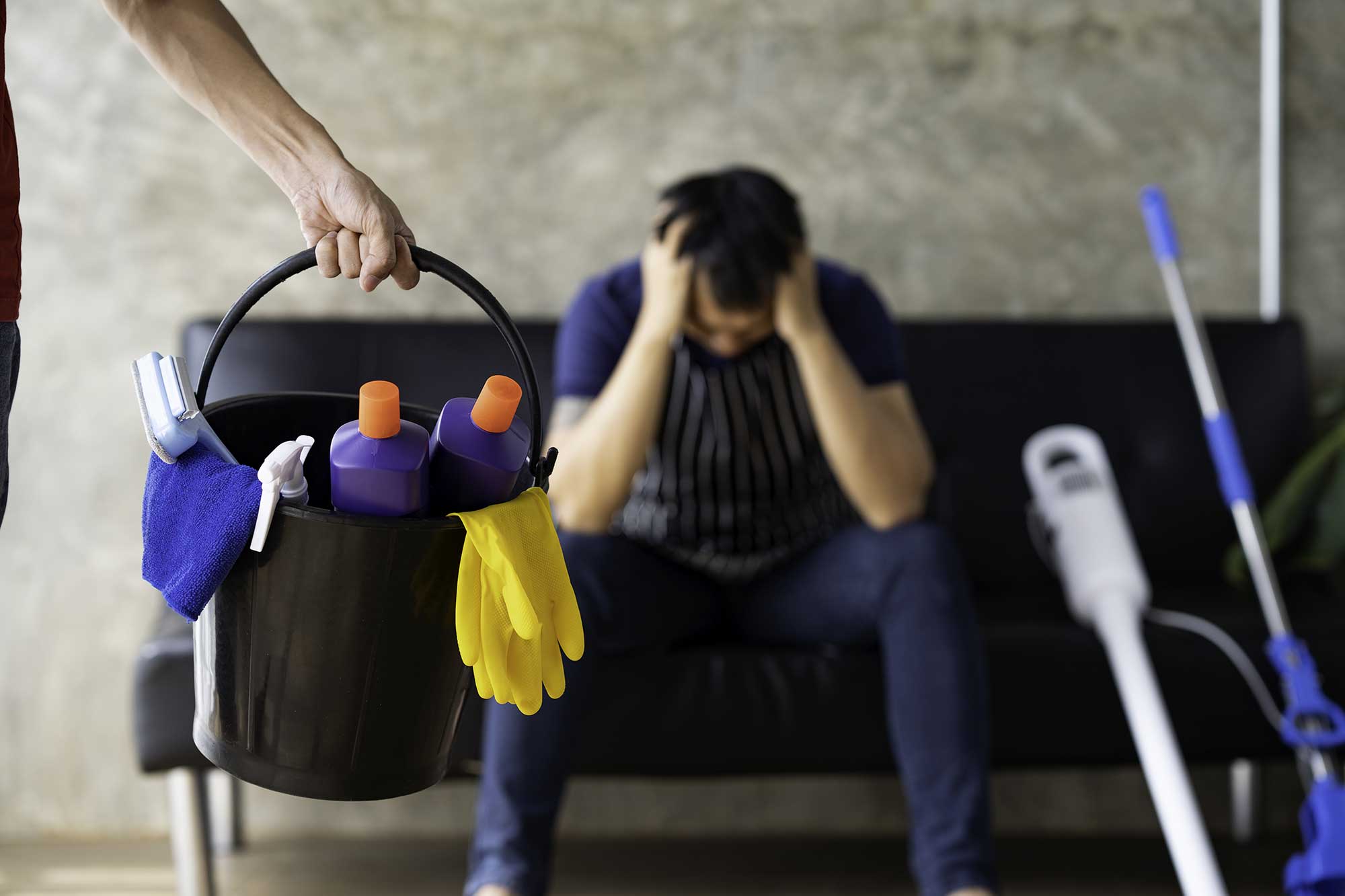 tired man with cleaning supplies at home