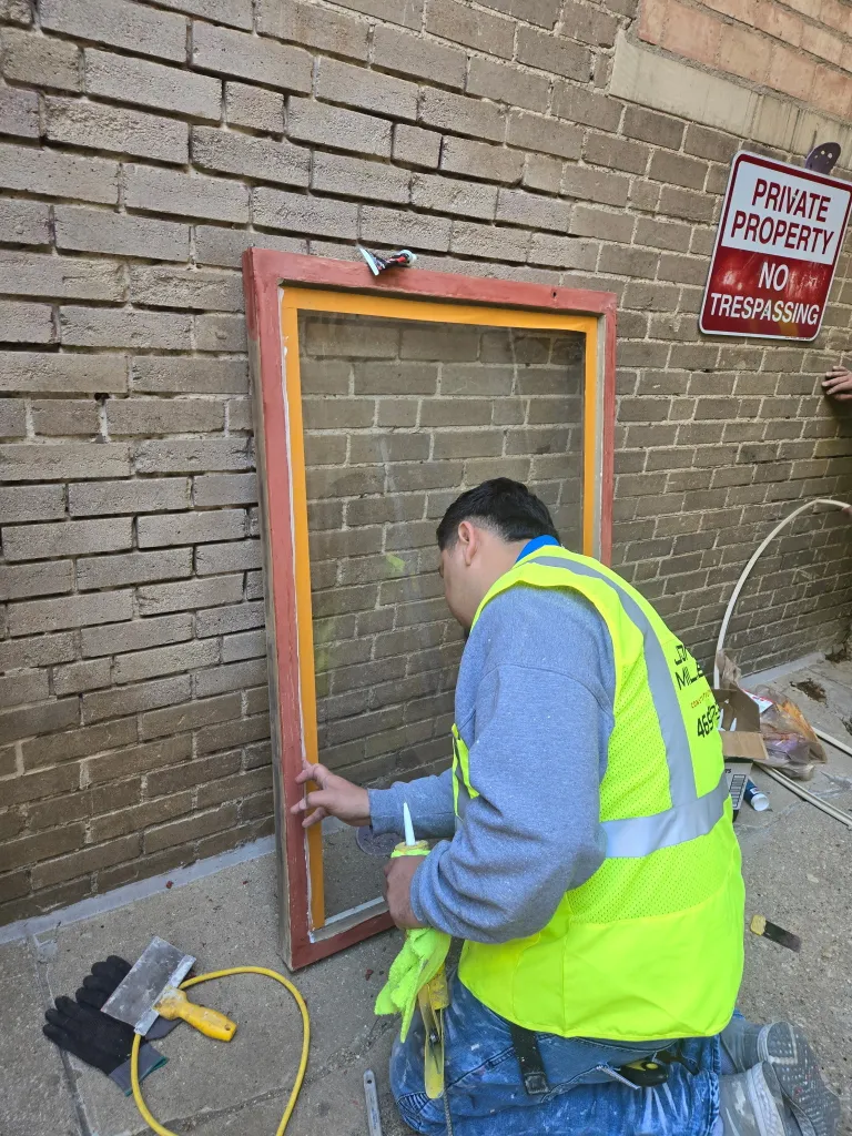 Fire damage restoration technician repairing exterior door frame damaged by fire