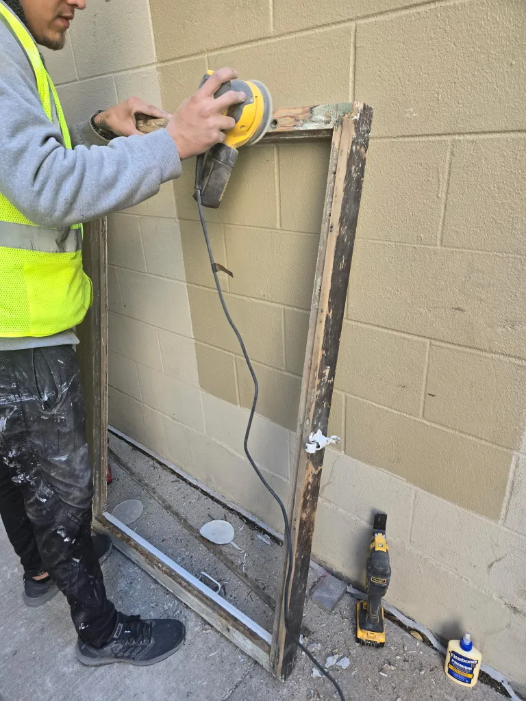 Professional fire damage repair of exterior door frame using specialized restoration equipment