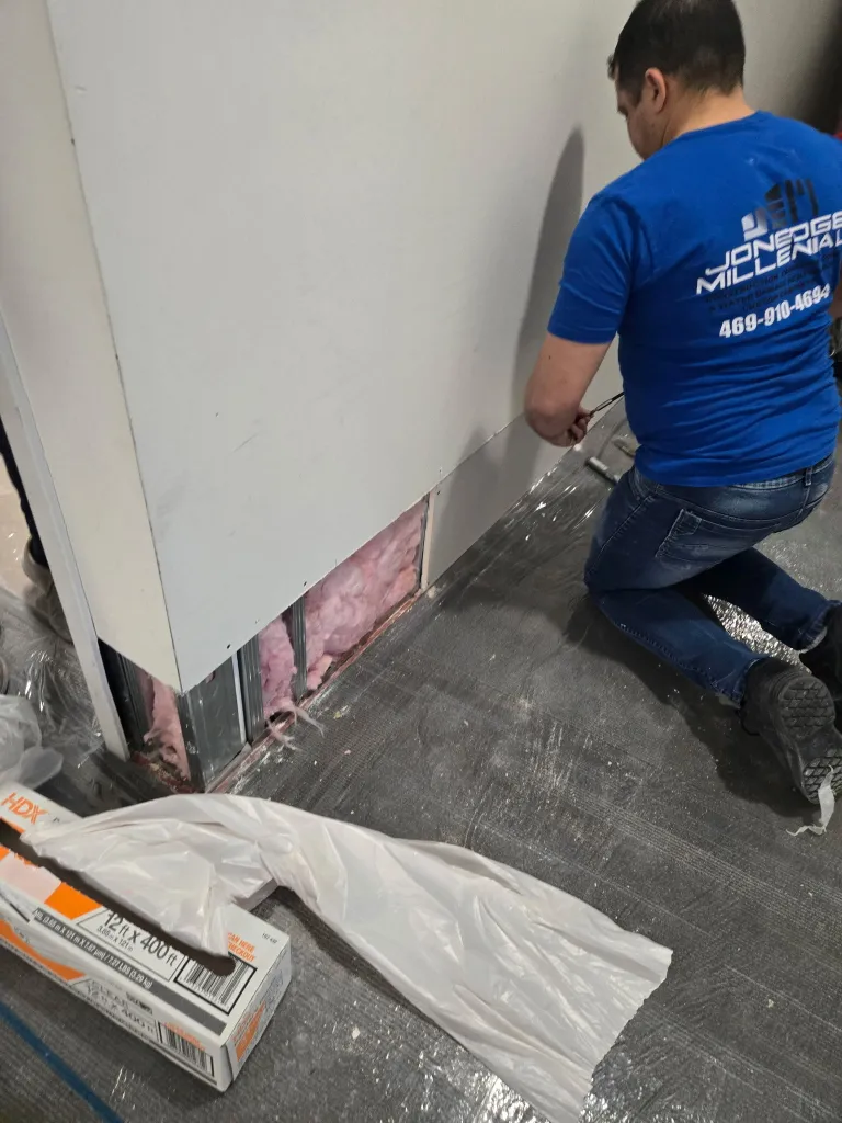 Certified technician performing water damage wall repair and insulation replacement